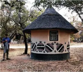  ?? Andrea Sachs / Washington Post ?? Shaun Thompson, of Texas, stands outside a Ndebele village hut, a lodging upgrade at Big Cave Camp near Matobo National Park in Zimbabwe. Most of the group chose to pitch a tent.