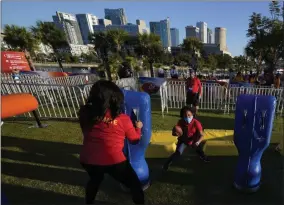  ?? DAVID J. PHILLIP - THE ASSOCIATED PRESS ?? Anaja Brackett, center, runs with a football at the NFL Experience for Super Bowl LV Friday, Jan. 29, 2021, in Tampa, Fla.