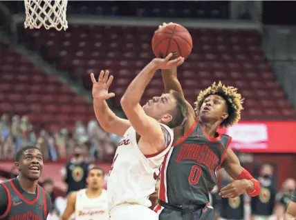  ?? MARY LANGENFELD / USA TODAY SPORTS ?? Ohio State’s Meechie Johnson Jr. blocks a shot by Wisconsin’s Brad Davison Saturday.