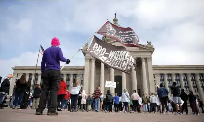  ?? ?? A person holds flags reading ‘pro-women pro-choice’ at a rally on the steps of the state capitol in Oklahoma City on 5 April. Photograph: Sarah Phipps/AP