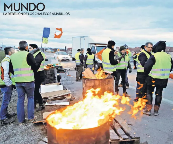  ??  ?? ► Manifestan­tes ocupan una rotonda como parte de la protesta de los “chalecos amarillos”, ayer en Roppenheim, Francia.