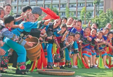  ?? LONG YUANBIN / FOR CHINA DAILY ?? Students in Miao ethnic costumes try to catch a silk ball at a cultural event at a middle school in Tongren, Guizhou province, on Monday. More than 2,000 students took part in the event. The city has added ethnic culture to its school curriculum.