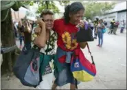  ?? ARIANA CUBILLOS — THE ASSOCIATED PRESS ?? Maria Martinez, left, mother of Jose Rafman and his wife, Juanita Bracho, cry Thursday after learning he died in a fast-moving fire a day prior that swept through a police station where he was being detained, in Valencia, Venezuela.