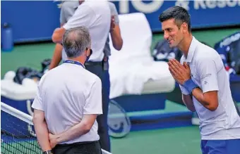  ?? AP PHOTO/SETH WENIG ?? Tennis star Novak Djokovic talks with the umpire after inadverten­tly hitting a line judge with a ball after reacting angrily to losing a point against Pablo Carreno Busta during the fourth round of the U.S. Open on Sept. 6. Djokovic wound up being defaulted, ending his run at the Grand Slam tournament in New York and halting his streak of overall wins at 29.