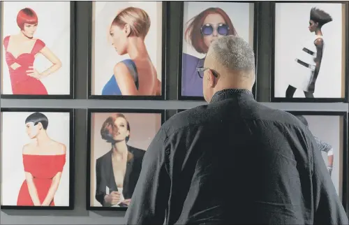  ??  ?? Curator David Sinclair looks at some of the prints on display at the Beehives, Bobs and Blow-Dries exhibition which runs until April 7 at the Barnsley Civic in Hanson Street. The exhibition examines innovation in hair care and fashion from the 1950s.