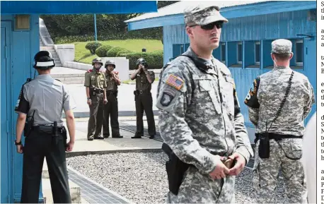  ?? — AP ?? Last guard post: File picture showing North Korean soldiers (background) watching the south side while South Korean (left) and US soldiers stand guard at the truce village of Panmunjom.