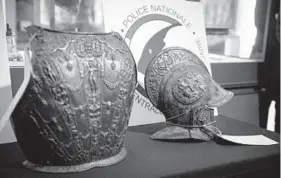  ?? THOMAS SAMSON/GETTY-AFP ?? A breastplat­e and ceremonial helmet stolen from the Louvre 38 years ago have been found.