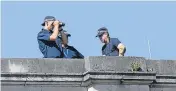  ??  ?? Police watch from the roof of the Palace.