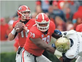  ??  ?? Georgia quarterbac­k Jake Fromm looks to pass against Georgia Tech behind the blocking of offensive lineman Isaiah Wilson on Saturday. The Bulldogs are No. 4 in the latest College Football Playoff rankings. JOHN BAZEMORE/AP