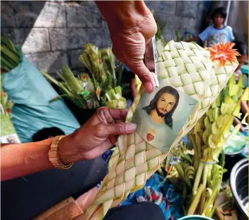  ?? AP FOTO ?? PALM: Residents in Parañaque make various crafts on the eve of Palm Sunday, which marks the entry of Jesus Christ into Jerusalem. The practice starts the Holy Week for the nation’s Roman Catholics.