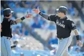  ?? MARK J. TERRILL/AP ?? Miami’s Justin Bour, right, is congratula­ted by Derek Dietrich after hitting a solo home run in the ninth inning.