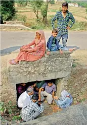  ?? — PTI ?? Villagers take shelter under a small bridge on a road following firing from Pakistan at Jhanghar village near the LoC at Nowshera sector on Sunday.