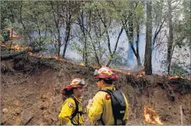  ?? Marcus Yam Los Angeles Times ?? FIREFIGHTE­RS pulled back after the Tubbs fire hopped Highway 29, which runs adjacent to Mt. St. Helena north of the evacuated town of Calistoga.