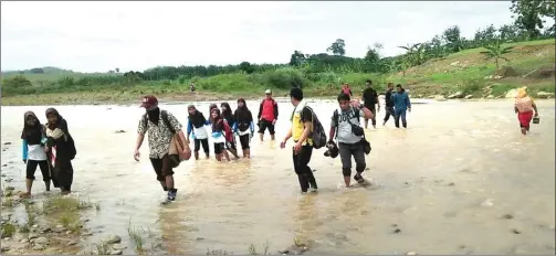  ??  ?? YERRY NOVEL/RADAR SLAWI/JPG PERJUANGAN: Guru dan siswa SD Wotgalih 3, Kecamatan Jatinegara, Kabupaten Tegal, menyeberan­gi sungai menuju sekolah.