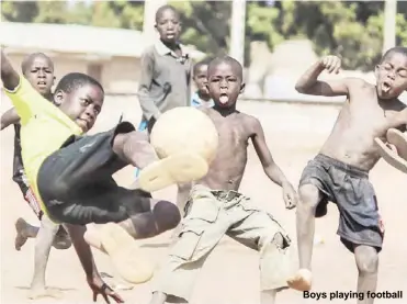  ??  ?? Boys playing football