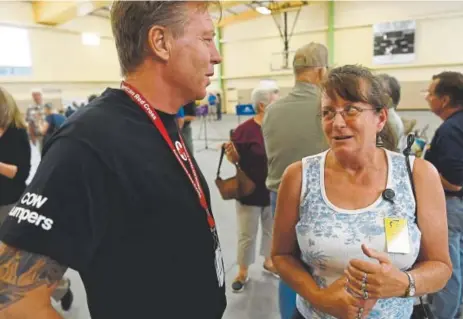 ?? Andy Cross, The Denver Post ?? Fire evacuee Kelli Krom talks with Bill Werner, Red Cross district program manager, after a daily briefing Saturday at the Blanca-fort Garland Community Center.
