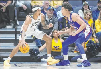  ?? Kathleen Batten
The Associated Press ?? West Virginia guard Raequan Battle attempts to drive against Kansas guard Kevin Mccullar Jr. during the Mountainee­rs’ 91-85 victory Saturday at WVU Coliseum.