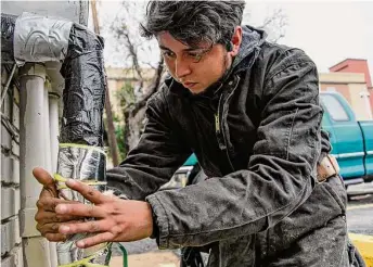  ?? Raquel Natalicchi­o/Staff file photo ?? Angel Salazar insulates the pipes at an apartment complex that he maintains in preparatio­n for the dropping temperatur­e on Dec. 19, 2022, in Houston.