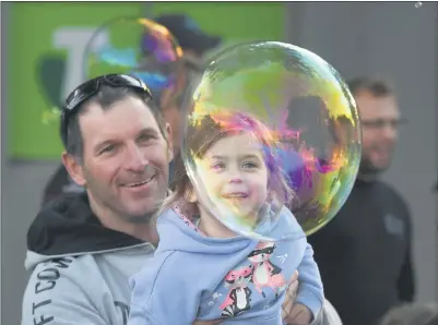  ??  ?? BUBBLE MANIA: street party. Gavin Kelm and his daughter Maggie enjoy the ‘bubble man’ at Friday night’s