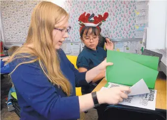  ?? GREG SORBER/JOURNAL ?? Samantha Detrana, 17, helps 6-year-old Divina Anaya-Rael on a research assignment. Detrana says helping second-graders has taught her how to communicat­e with kids.