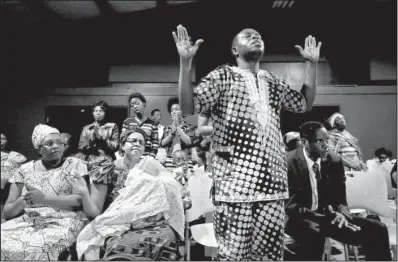  ?? Los Angeles Times/GARY CORONADO ?? Kesereka Mapendano, a native of Congo, joins in a worship service recently at Pantego Bible Church in Fort Worth.