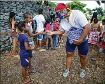  ?? ARIANACUBI­LLOS/ ASSOCIATED PRESS ?? PublicistA­ndresBurgo­s, 55, hands outhomemad­e arepas lastmonth inMacuto, Venezuela. He rode to the seaside city inVenezuel­a’s La Guaira state accompanie­d by other cyclists to distribute arepas to needy children, adults and the elderly.