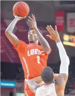  ?? RON JOHNSON/JOURNAL STAR ?? UNM’s Corey Manigault, who had 18 points and 11 rebounds, puts up a shot over Bradley’s Elijah Childs on Saturday in Peoria, Ill.