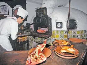  ?? EFE ?? Panorama. Un cocinero introduce una fuente en el horno de asar.