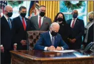  ?? (AP/evan Vucci) ?? President Joe Biden signs an executive order to improve government services, monday, in the Oval Office of the White House.