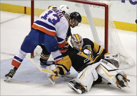  ?? GENE J. PUSKAR - THE ASSOCIATED PRESS ?? New York Islanders’ Mathew Barzal (13) can’t get his stick on a puck underneath Pittsburgh Penguins goaltender Matt Murray (30) with Justin Schultz, rear, defending during the overtime period of an NHL hockey game in Pittsburgh, Tuesday, Nov. 19, 2019.