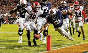  ?? KEVIN C. COX / GETTY IMAGES ?? Auburn running back Kerryon Johnson dives past Georgia’s Deandre Baker for a touchdown. Baker ran for 167 yards and caught a 55-yard touchdown pass as the Tigers handed the Bulldogs their first defeat.