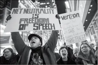  ?? ASSOCIATED PRESS ?? IN THIS DEC. 7, 2017 FILE PHOTO, DEMONSTRAT­ORS RALLY IN SUPPORT of net neutrality outside a Verizon store in New York. Consumers aren’t likely to see immediate changes after Monday’s formal repeal of Obama-era internet rules that had ensured equal...