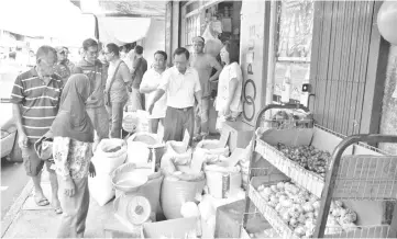  ??  ?? Hii explaining to shop operators that they are not allowed to block the pedestrian walkway with goods outside their premises.