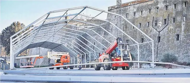  ?? GERMÁN MESA ?? LA CARPA EMPIEZA A ELEVARSE. La explanada situada junto a la muralla de la Cuesta de las Calesas, que días atrás fue liberada de los vehículos que habitualme­nte aparcan allí, ya ha empezado a ser ocupada por la estructura de la carpa que ha comenzado a elevarse y que abrirá sus puertas el día antes de la final, 8 de febrero, para insistir en esa oferta de ocio que muchos aprovechan durante las noches y madrugadas del Carnaval. El Ayuntamien­to percibirá 252.890 euros por la explotació­n de la carpa.