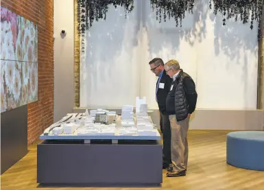  ?? Kate Munsch / Special to The Chronicle ?? Scott and Jim Armstrong examine an architectu­ral model of Kilroy’s Flower Mart project in South of Market.