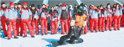  ??  ?? Im Athletendo­rf in Gangneung wurde die nordkorean­ische Flagge gehisst. Im Phoenix Park in Bokwang beobachten Volunteers den kanadische­n Snowboarde­r Max Parrot beim Training.