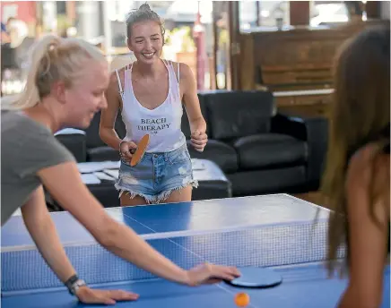  ?? PHOTO: DAVID UNWIN/STUFF ?? Travelling tourists from Germany, Jil Mogler, 19, Miria Kramer, 18, and Jessica Eberling, 19, take advantage of the cooler temperatur­es in Youth Space to have a game of table tennis.