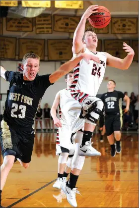  ?? Visit nwadg.com/photos for more pictures from the game. NWA Democrat-Gazette/ANDY SHUPE ?? Westin Church (24) of Pea Ridge drops in a layup as West Fork’s Justin Bivens attempts to block the shot Wednesday during the 4A-North Regional Tournament at the Tiger Dome in West Fork.