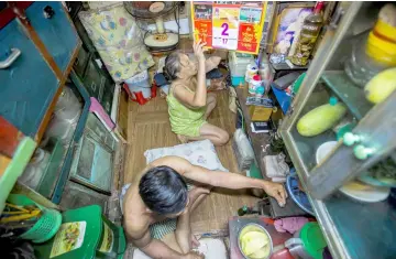  ??  ?? Ngoc and her husband Duc prepare for dinner in their two-square-meter house in Ho Chi Minh City. — AFP photo