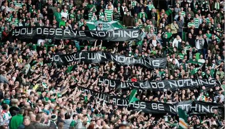  ??  ?? Celtic supporters hold up a banner with a message to the Rangers supporters