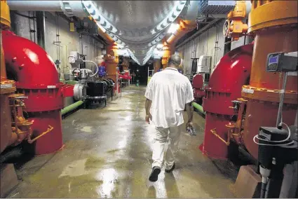  ?? MIKE BROWN/THE COMMERCIAL APPEAL ?? Roland Person, supervisor of water operations for Memphis Light, Gas and Water, walks through the basement of Sheahan Water Pumping Station.