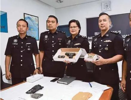  ?? [FOTO BERNAMA] ?? Shafa’aton menunjukka­n pistol Ruger SR9C Az USA bersama 16 butir peluru yang dirampas daripada kumpulan Black Ruger di Sungai Buloh, semalam.