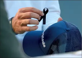  ?? ?? mark of respect: Australian golfer Lucas Herbert attaches a black ribbon to his cap at the BMW PGA Championsh­ip at Wentworth yesterday