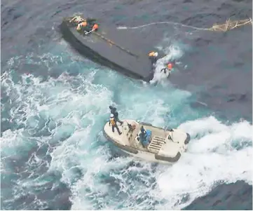  ??  ?? Picture shows a Japan Coast Guard rescue team approachin­g a capsized North Korean boat (top) on the Sea of Japan (East Sea), about 360 kilometres northwest of the Noto Peninsula in Ishikawa. — AFP photo