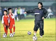  ??  ?? Diego Maradona teaches children soccer skills in Dongguan, Guangdong province.