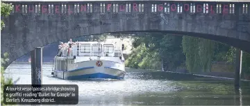  ??  ?? A tourist vessel passes a bridge showing a graffiti reading ‘Bullet for Google’ in Berlin’s Kreuzberg district.