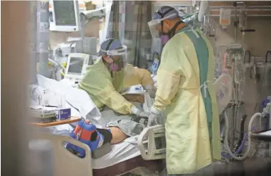  ?? PHOTOS BY DAVID WALLACE/THE REPUBLIC ?? Nurses Danielle Coates, left, and Alex Clark tend to a COVID-19 patient at Valleywise Health Medical Center in Phoenix. Much of the hospital now treats for COVID-19.