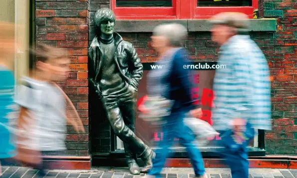  ??  ?? Above: a statue of the young John Lennon, “watching the wheels” go by outside the Cavern Club; below: Liverpool fans celebrate after winning the Champions League Final in 2019