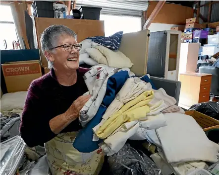  ?? MARTIN DE RUYTER/STUFF ?? Rachel Chapman-Munro sorts linen at Nelson’s ReStore. A pile of donated sheets hid a bag of money being stored away by a man, unbeknowns­t to his wife who donated the linen.