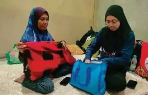  ?? (Foto Mohamed Farid NOH/BH) ?? Alfian dan anaknya, Nor Amelia Sarman mengemas pakaian yang sempat dibawa di PPS Dewan MBIP Skudai, Johor Bahru, semalam.